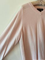 Front view of light pink cashmere V-neck sweater on hanger