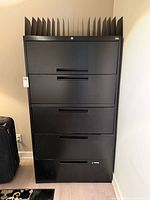 Front view of black 5-drawer cabinet with organizers on top