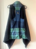 Interior view of black vest showing blue/green tartan lining and label area