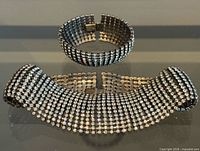Necklace curved with bracelet standing; shows rhinestone rows and clasps