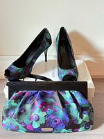 Shoes displayed on box with matching clutch in front
