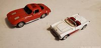 Top view of red coupe and white convertible model cars