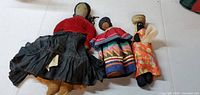 Three handcrafted cloth dolls laid flat