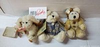 Front view of three cream teddy bears with tags intact