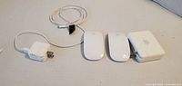 Top view of two Magic Mouse, AirPort Express, USB power adapter and cable