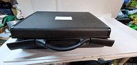Closed briefcase top view showing textured black shell