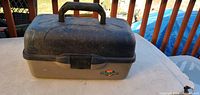 Closed tackle box front view showing handle, latch, logo