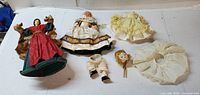 All items laid out: angel topper, porcelain doll, doll legs, doll head, yellow dress, white petticoat