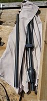 Folded beige canopy, upper pole with crank hub, separate lower pole section