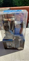 Front view of packaged heated travel mug showing digital control panel and box graphics