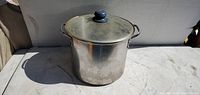 Front view of stainless steel stock pot with lid and handles