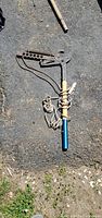 Full view of pole lopper showing cutting head, rope and handle