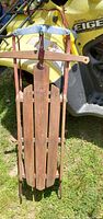 Front view of wood sled showing slats, runners, steering bar