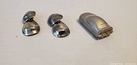 Front view of two clip-on earrings and metal model car