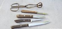Overall lot view: four steak knives and scissor tongs