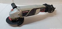 Full view of Task Force angle grinder, disc and cord visible