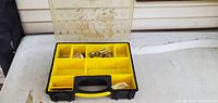 Organizer open showing nine yellow compartments and contents