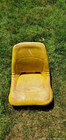 Top view of yellow seat showing wear and dirt