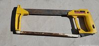 Full view of hacksaw showing yellow handle and metal frame