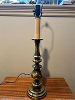 Full view of brass candlestick lamp on table