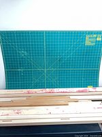 Overall view of green rotary cutting mat and bundle of wooden stretcher bars