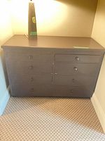 Front view of dark brown seven-drawer dresser showing all drawers and knobs