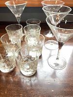 Group of seven etched lowball glasses and four martini glasses