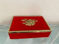 Top view showing red tin with gold rose and trim