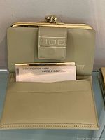 Wallet open showing interior pocket, ID card insert, gold-tone frame