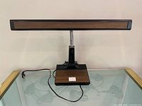 Front view of Mobilite desk lamp showing faux woodgrain base and shade