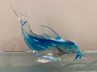 side view of clear and blue glass dolphin figurine