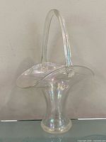 Front view of clear iridescent Steuben bridal basket showing overall form and arch handle