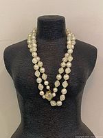 Full view of three-strand necklace on display bust