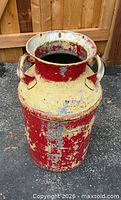 Full view of the milk can showing chipping paint and rust