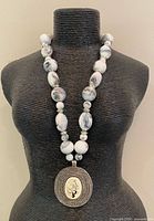 Full view of necklace on display form showing bead arrangement and pendant length