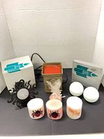Group shot showing all items in lot: boxed sconces, wax warmer, candles