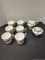 Six mugs, creamer, sugar bowl grouped
