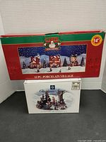 Both boxed sets shown: Santa's Trim Shoppe 12 pc village and Christmas Street diorama