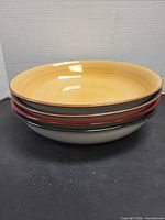 Stack of four coloured stoneware plates