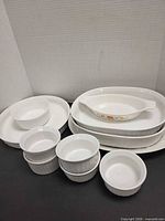 Group shot of all dishes stacked: oval handled dish, oval casseroles, round casseroles, ramekins