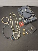 Group shot showing necklaces, bracelets, pins and boxed set