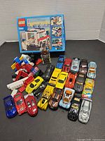 Group shot of Lego box, loose bricks, minifigure and full selection of die-cast cars