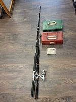 Full lot: two rods, reel attached on one, red and green tackle boxes, metal tin