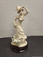 Front view of Armani Florence figurine showing lady, dogs, wood base
