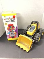 Gumball machine box and Little Tikes bulldozer side by side