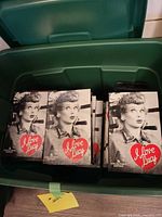 Rubbermaid tote containing stacks of sealed "I Love Lucy" VHS tapes
