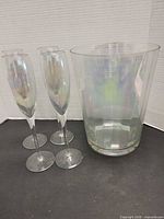 Full lot showing four champagne flutes beside ice bucket