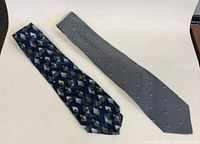 Both designer ties laid flat showing full length and patterns