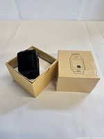 Opened box showing black smartwatch in cardboard insert