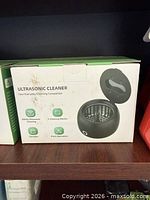 Front of boxed ultrasonic cleaner showing product image and feature list